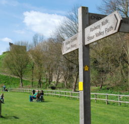 Stour Valley Path wooden finger post sign at Clare Castle Country Park on a sunny day