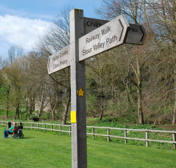 Stour Valley Path wooden finger post sign at Clare Castle Country Park on a sunny day