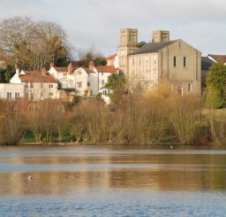 view of buildings across Diss Mere in the autumn