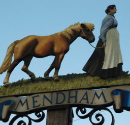 Mendham village sign of a woman leading a horse