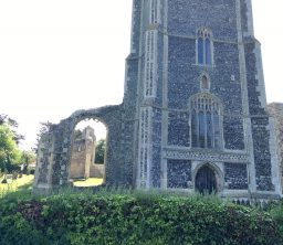 The imposing square flint tower and ruined aspects of St Andrew's Church, Walberswick