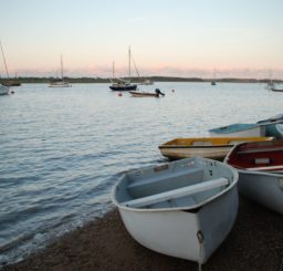 a view across the water at Bawdsey - lots of sailing dinghies moored in the water and several small rowing boats tied up on the beach