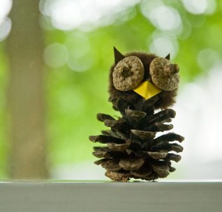 A small owl decoration made out of a pine cone