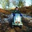 man in hat, fleece and gloves using the tramper mobility vehicle at Dunwich Heath on a winter's day